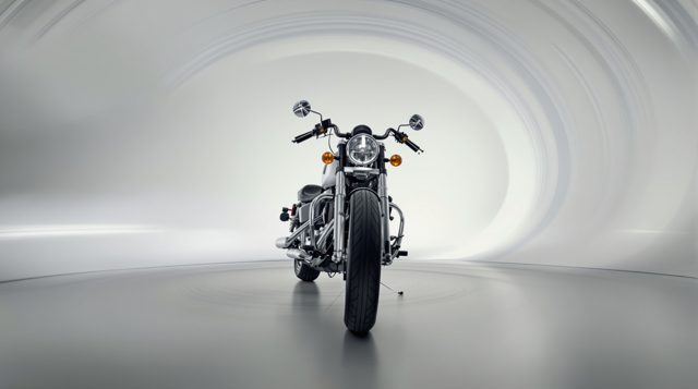 Orbit example: a classic motorcycle on a studio floor, the background sweeping in circular motion blur around it