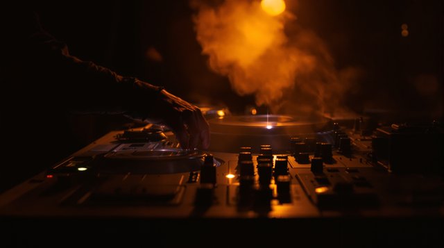 Deep House example: turntables in a smoky dim club at 4am, warm amber light, a chopped vocal record sleeve