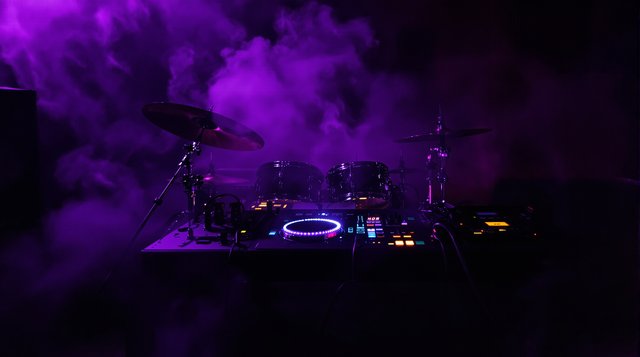 Trap example: an 808 drum machine glowing in a dark studio, booming subwoofer, purple smoke